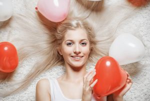 Woman holding heart shaped balloons