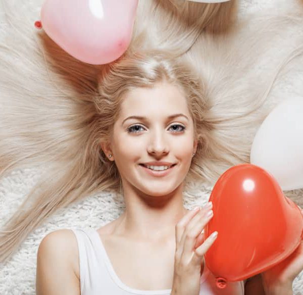 Woman holding heart shaped balloons