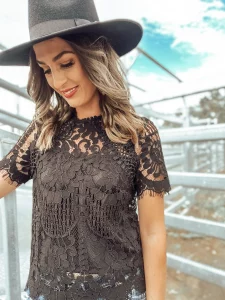 woman in. lace top and black hat