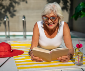 Middled aged woman with glasses reading a book about why it is important to prioritise youself